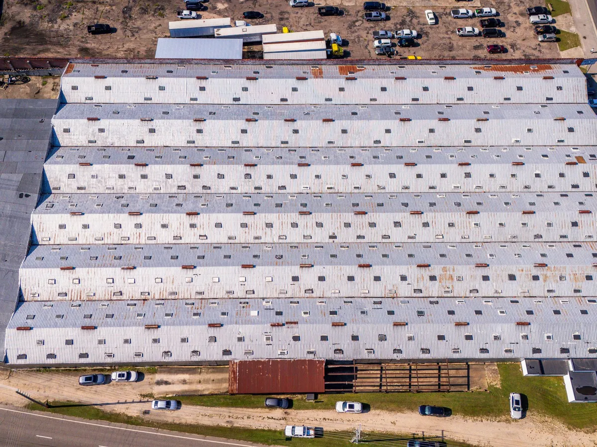 Aerial view of a large commercial building with a metal roof