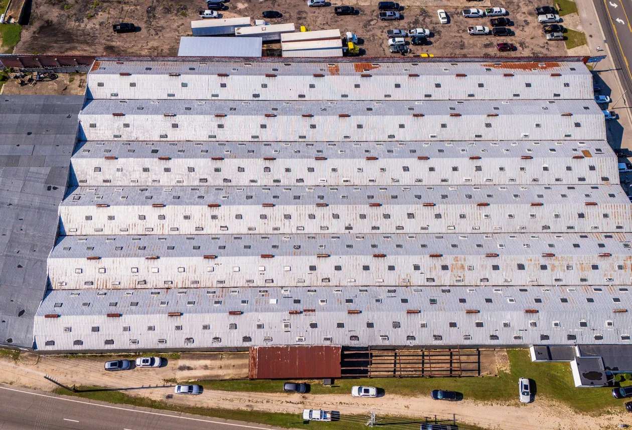 Aerial view of a large commercial building with a metal roof