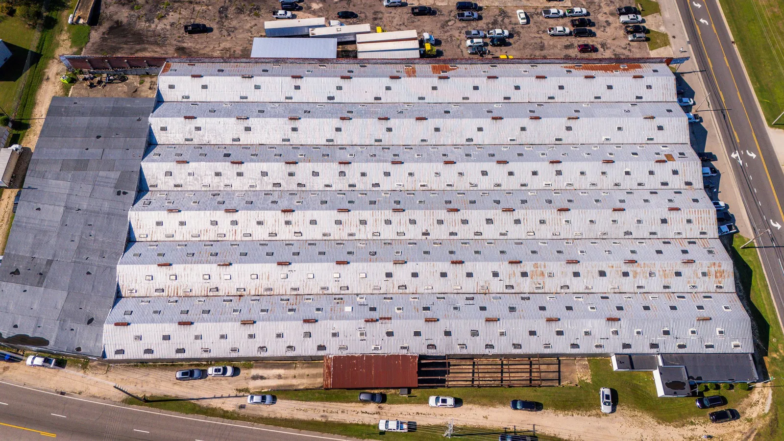 Aerial view of a large commercial building with a metal roof