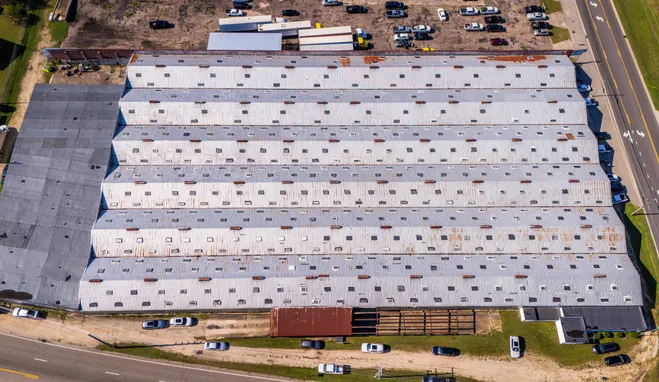 Aerial view of a large commercial building with a metal roof